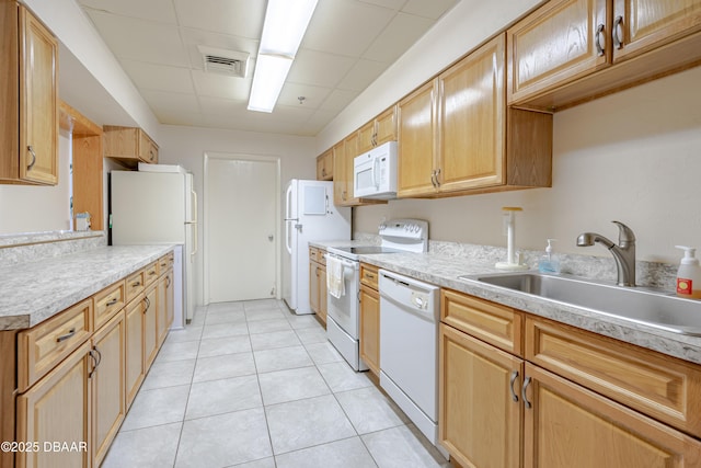 kitchen featuring white appliances, visible vents, light countertops, a sink, and light tile patterned flooring