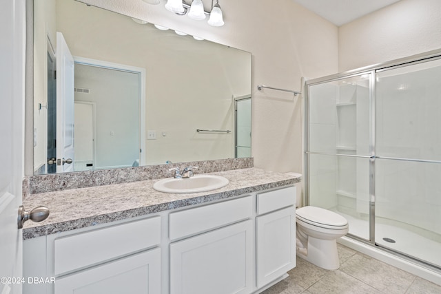 bathroom featuring toilet, vanity, an enclosed shower, and tile patterned flooring