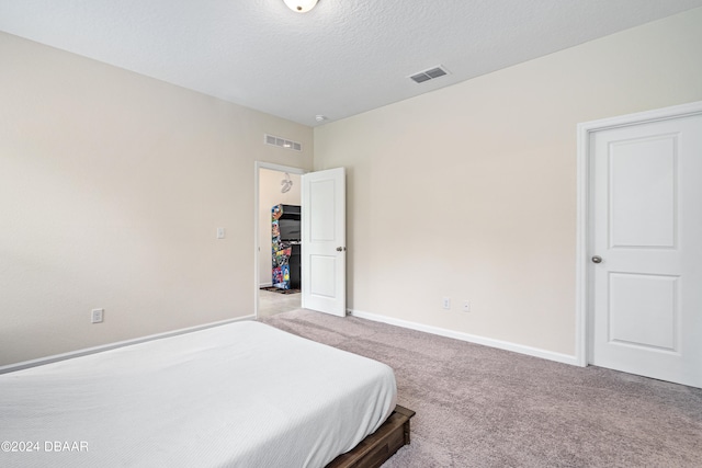 bedroom with a textured ceiling and light carpet