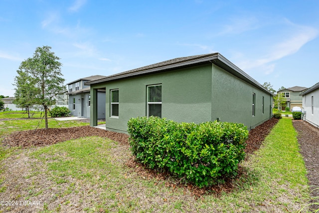 view of side of home with a yard