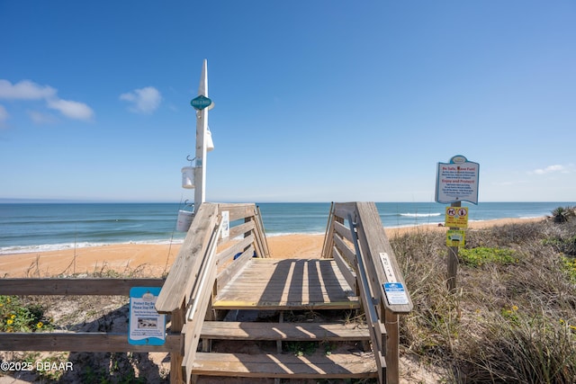 view of community with a water view and a beach view