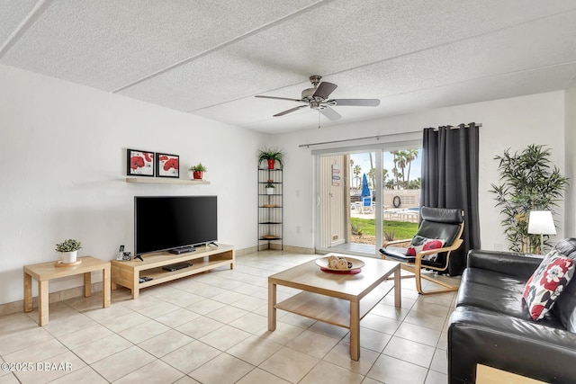 living room featuring light tile patterned flooring, ceiling fan, and baseboards