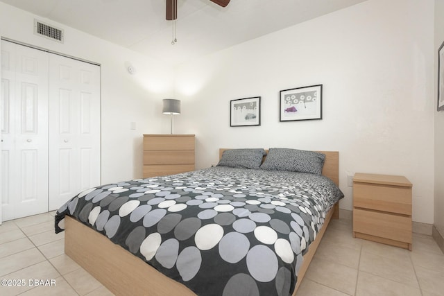 bedroom with ceiling fan, visible vents, tile patterned flooring, and a closet