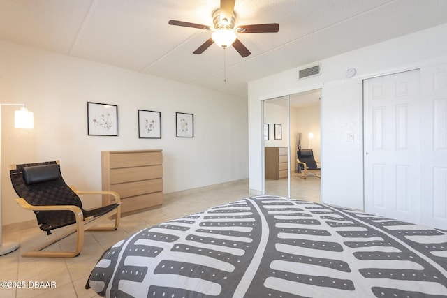 tiled bedroom featuring a ceiling fan, two closets, and visible vents