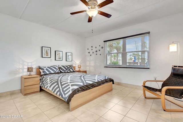 bedroom with light tile patterned flooring, ceiling fan, baseboards, and a textured ceiling