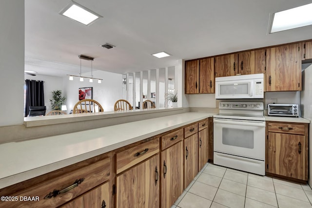 kitchen with brown cabinetry, visible vents, white appliances, light countertops, and light tile patterned floors