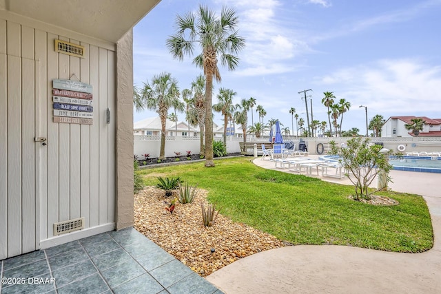 view of yard featuring a community pool, a patio, fence, and visible vents