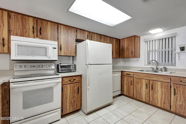 kitchen featuring brown cabinets, a sink, light countertops, a toaster, and white appliances