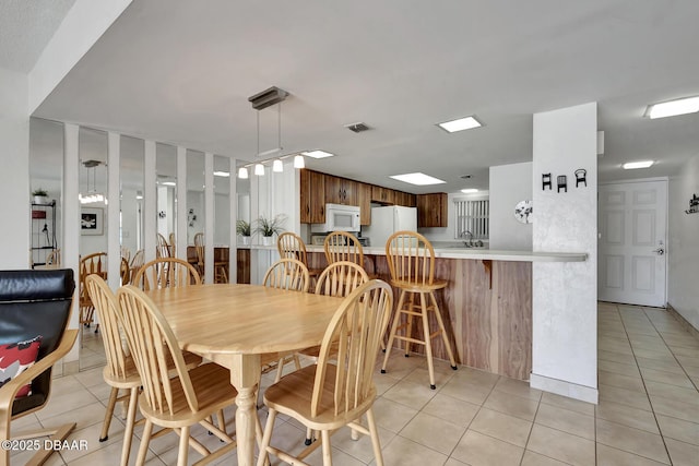 dining space featuring visible vents and light tile patterned flooring