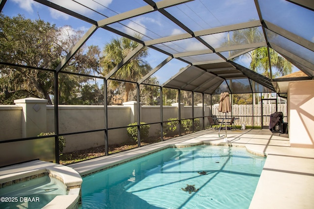 view of swimming pool featuring glass enclosure and a patio area