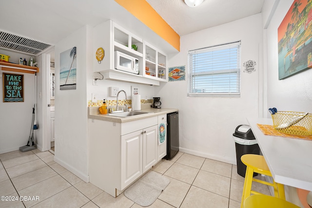 bar with white cabinets, light tile patterned floors, sink, and dishwasher