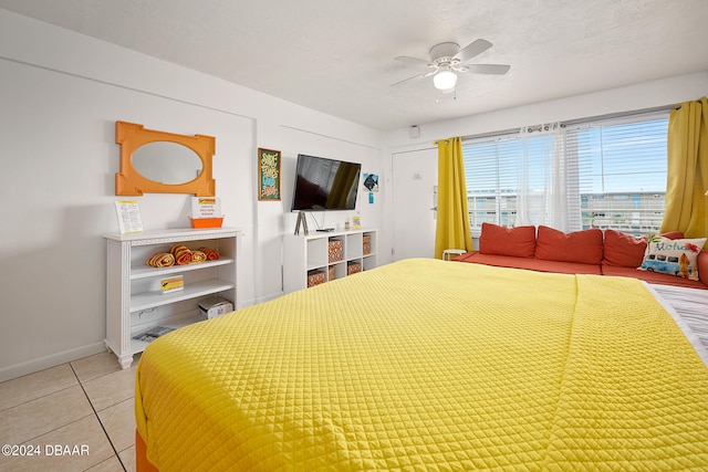 tiled bedroom with a textured ceiling and ceiling fan