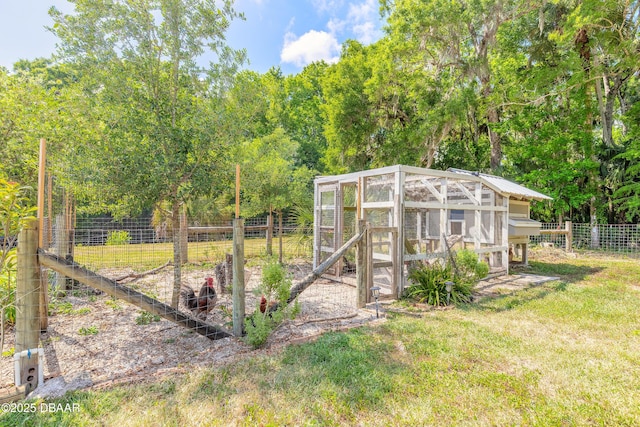 view of yard featuring fence, exterior structure, and an outbuilding