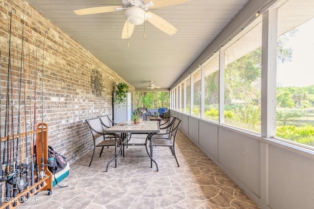 sunroom with outdoor dining area and a ceiling fan