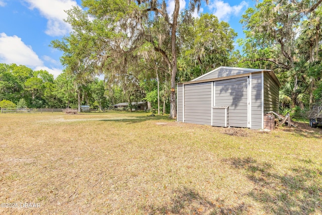 view of yard featuring an outdoor structure and fence