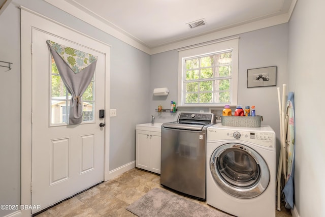 laundry room featuring crown molding, baseboards, washer and clothes dryer, a sink, and cabinet space