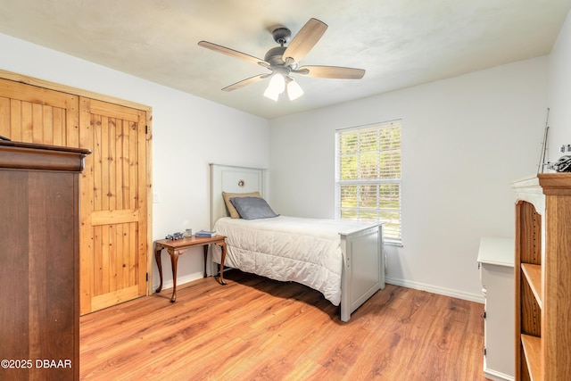 bedroom with baseboards, ceiling fan, and light wood-type flooring
