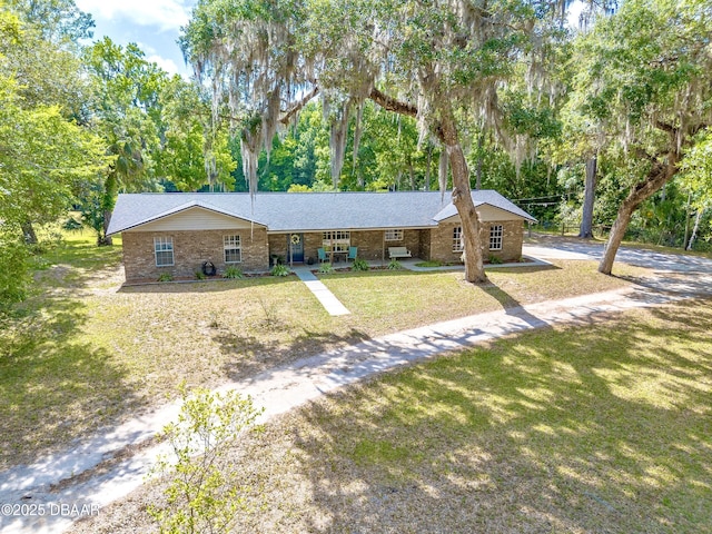 single story home featuring brick siding and a front yard
