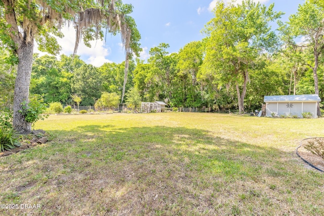 view of yard with fence and an outdoor structure
