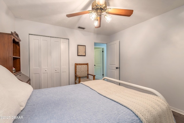 bedroom featuring visible vents, baseboards, ceiling fan, and a closet
