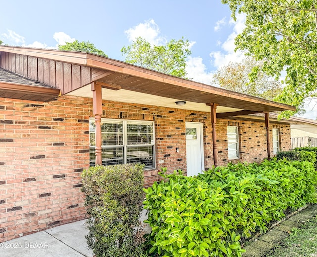 doorway to property featuring brick siding