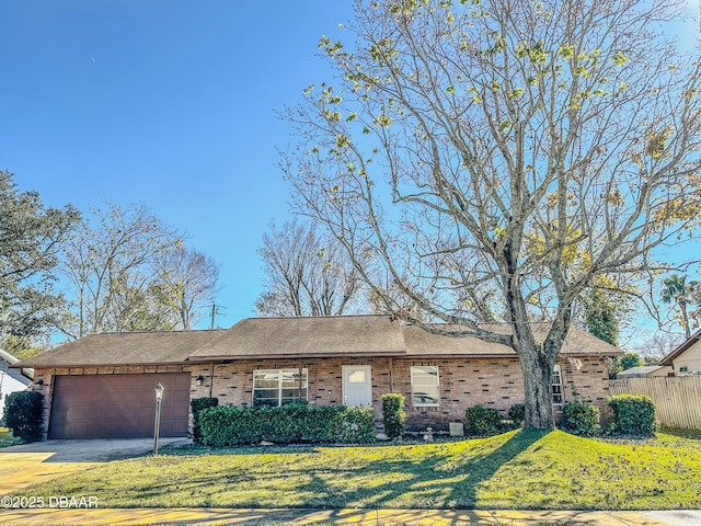 ranch-style home featuring a garage, brick siding, driveway, and a front yard