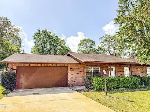 single story home featuring a front yard, driveway, roof with shingles, a garage, and brick siding