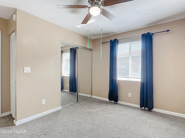 unfurnished bedroom featuring a closet, carpet flooring, and ceiling fan