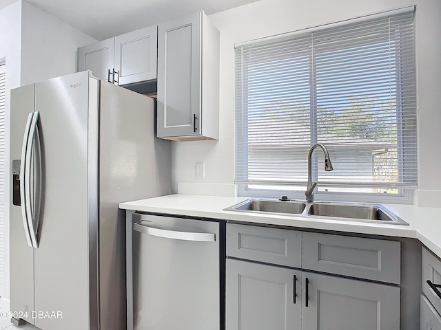 kitchen featuring stainless steel appliances, gray cabinetry, and sink