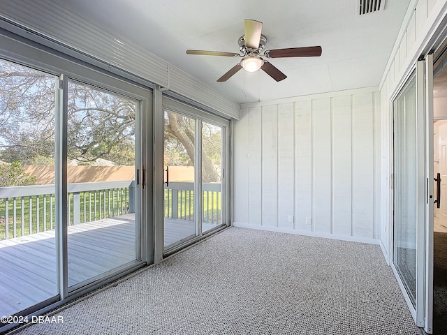 unfurnished sunroom featuring ceiling fan