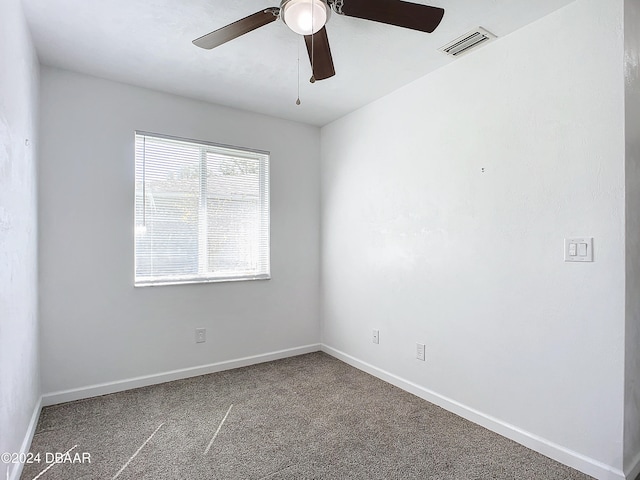 carpeted spare room featuring ceiling fan