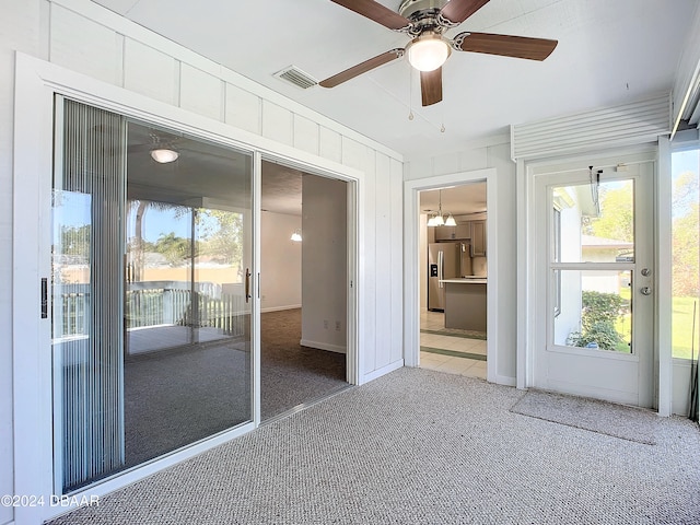 unfurnished sunroom featuring ceiling fan