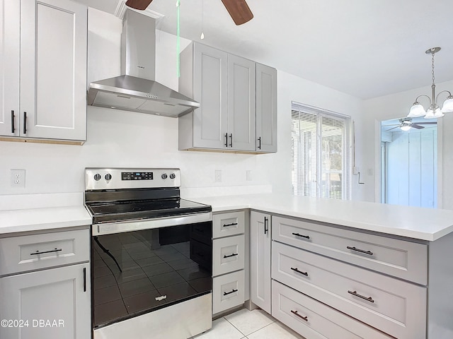 kitchen with stainless steel range with electric cooktop, wall chimney range hood, light tile patterned floors, hanging light fixtures, and kitchen peninsula