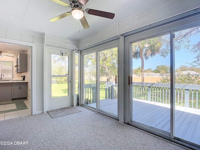 unfurnished sunroom with ceiling fan