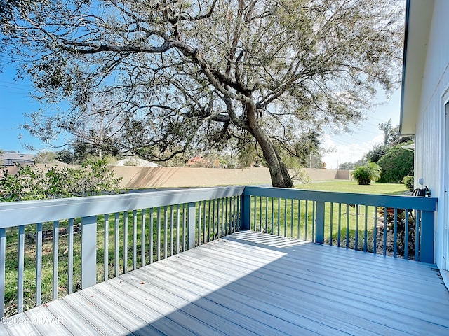 wooden terrace featuring a yard