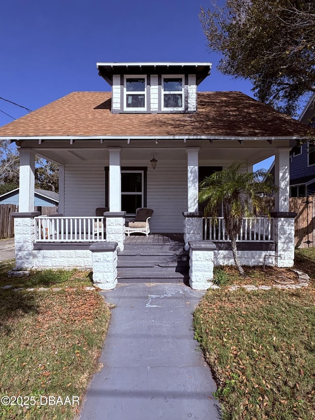 view of front of house with covered porch and a shingled roof