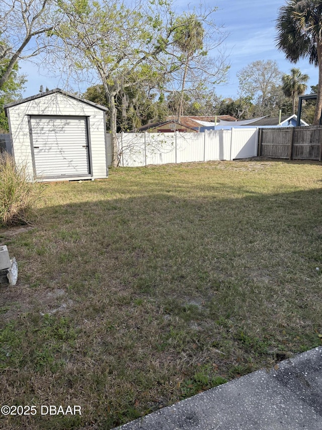 view of yard featuring an outbuilding, a storage unit, and a fenced backyard