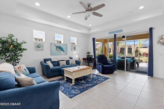 living area featuring recessed lighting, a tray ceiling, light tile patterned flooring, and a ceiling fan