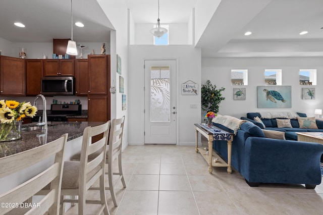 kitchen featuring pendant lighting, dark stone countertops, recessed lighting, appliances with stainless steel finishes, and light tile patterned flooring