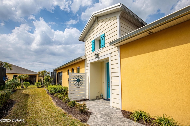 property entrance featuring a yard and stucco siding