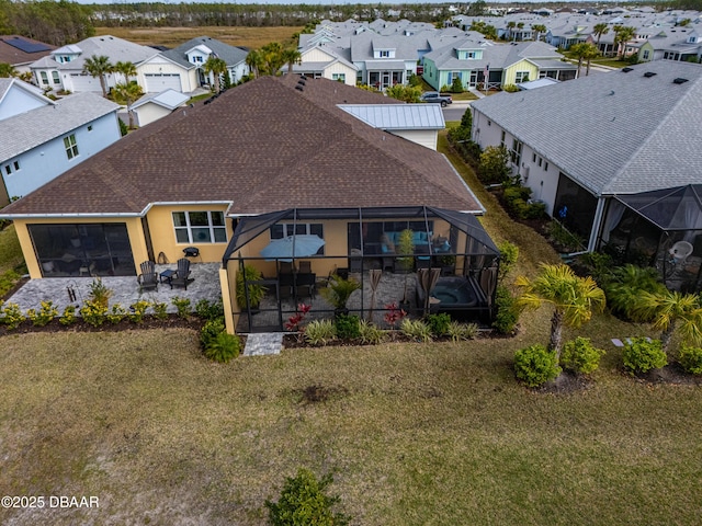 rear view of property featuring an attached garage, a patio area, a residential view, and roof with shingles