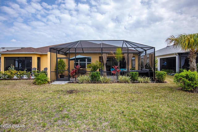 rear view of house with stucco siding, a patio, a yard, and a lanai