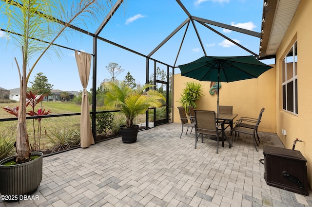 view of patio / terrace featuring glass enclosure and outdoor dining space