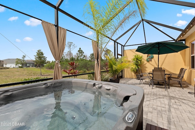 view of patio / terrace featuring glass enclosure, outdoor dining space, and a hot tub