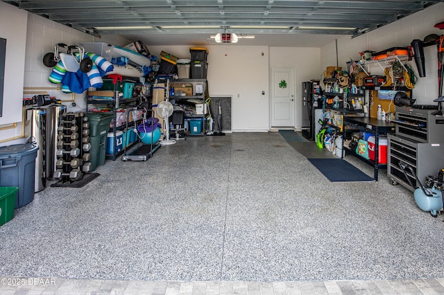 garage featuring concrete block wall and a garage door opener