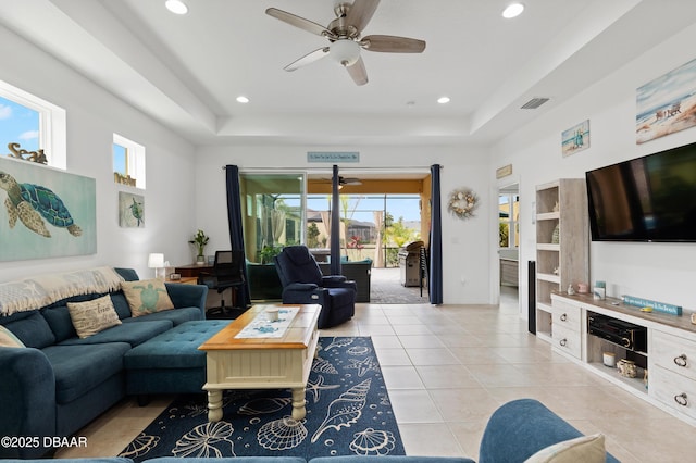 living area featuring a tray ceiling, light tile patterned floors, recessed lighting, and visible vents