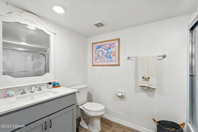 full bathroom featuring a shower with shower door, toilet, wood finished floors, vanity, and baseboards