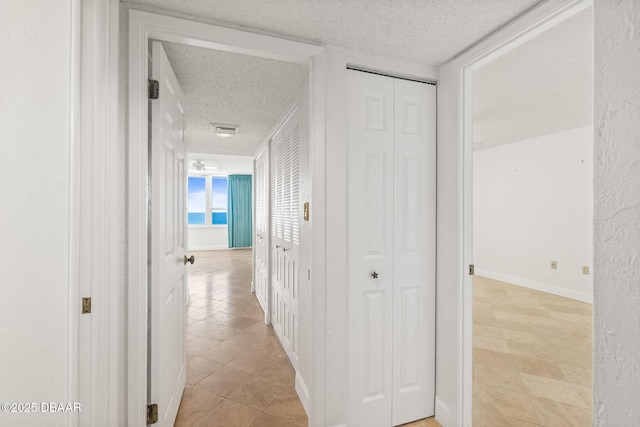 2987 S Atlantic Ave Unit 903, Daytona Beach Shores, FL 32118 - hall featuring a textured ceiling, light tile patterned flooring, and baseboards