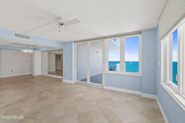 2987 S Atlantic Ave Unit 903, Daytona Beach Shores, FL 32118 - unfurnished room featuring a chandelier, a ceiling fan, a textured ceiling, baseboards, and a water view