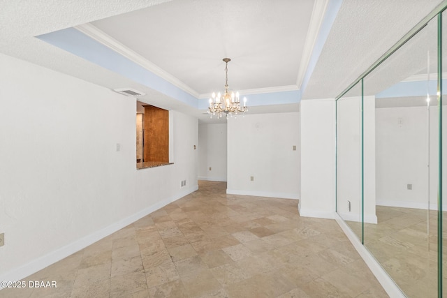 2987 S Atlantic Ave Unit 903, Daytona Beach Shores, FL 32118 - empty room with a raised ceiling, a chandelier, ornamental molding, baseboards, and stone finish floors